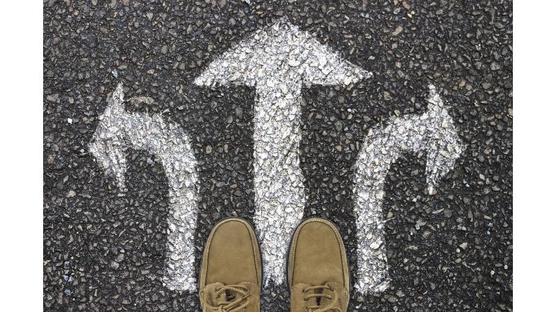 道路に書かれた3方向に伸びる矢印と男性の靴