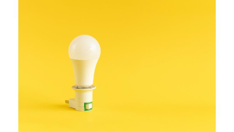 黄色の背景と一つの電球