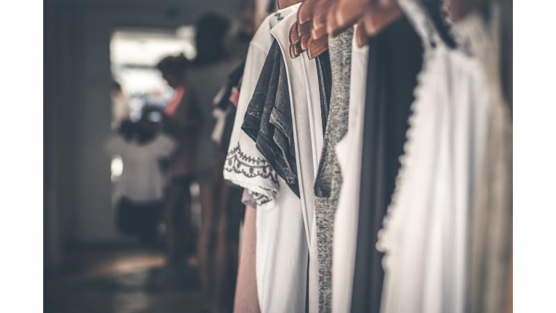 モノトーンの服がハンガーに沢山並べられている。