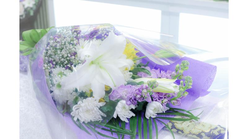 紫の包装紙に包まれた花束