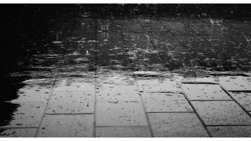 雨に打ち付けられているアスファルトの地面。