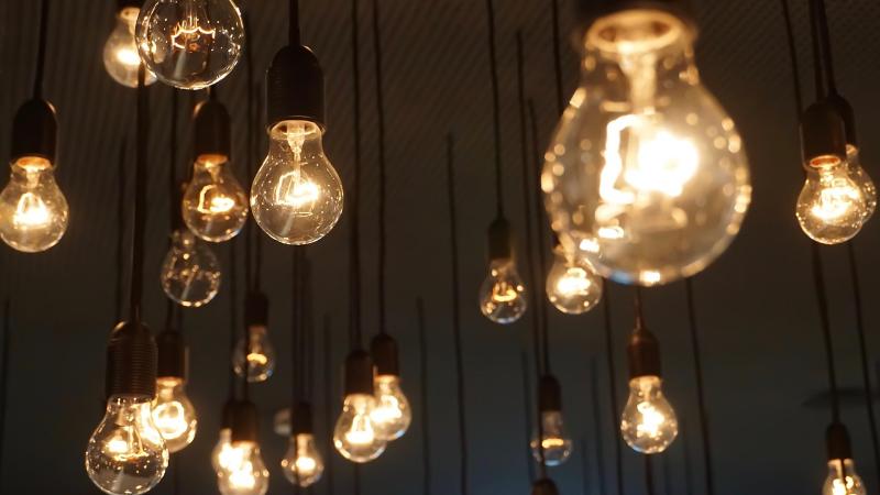 天井から何個もの電球がぶら下がっている、暖かい写真です。