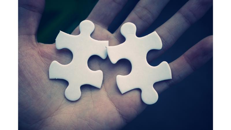 手のひらに置かれた2つの白いパズルピース