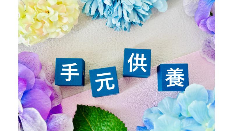 「手元供養」の文字が入ったブロックと周りを囲む造花