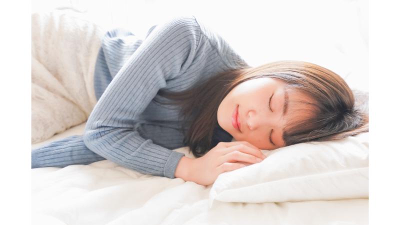 布団で眠る女性