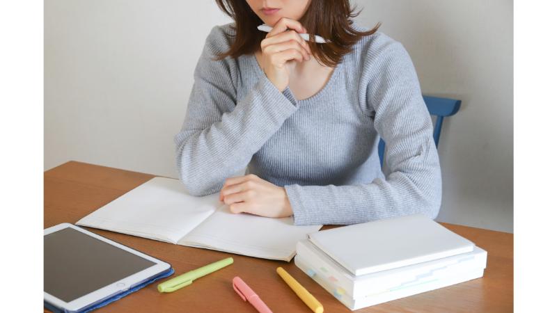ノートを拡げて勉強する女性