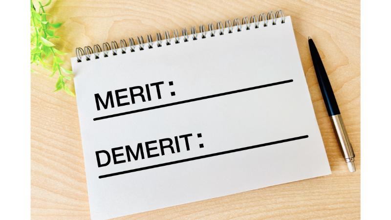 スケッチブックに書かれた「MERIT」「DEMERIT」の文字とボールペン