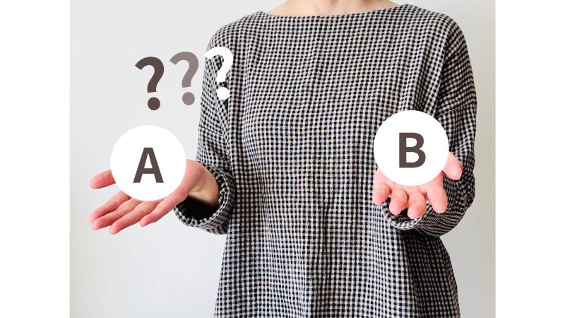 AとBの選択肢を掲げる女性の手元
