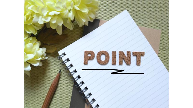 ノートに置かれたPOINTの文字に切り抜かれたコルクボード
