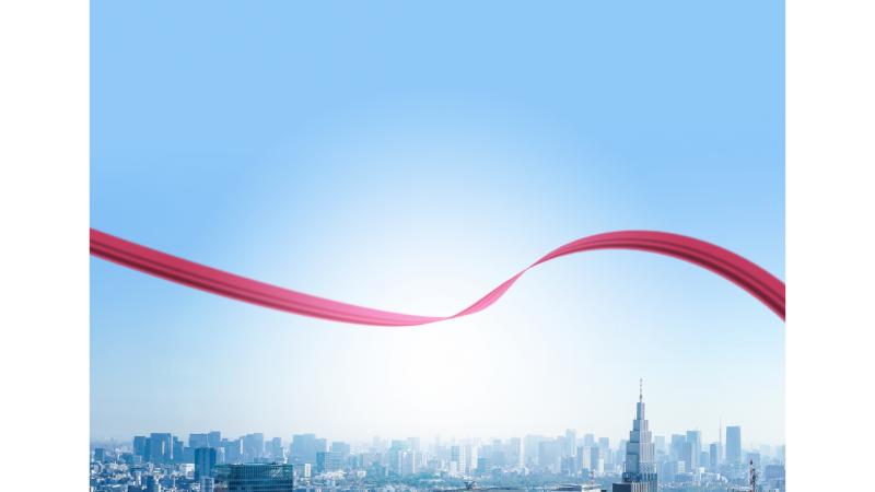 都心の上空に横に伸びる赤いリボン