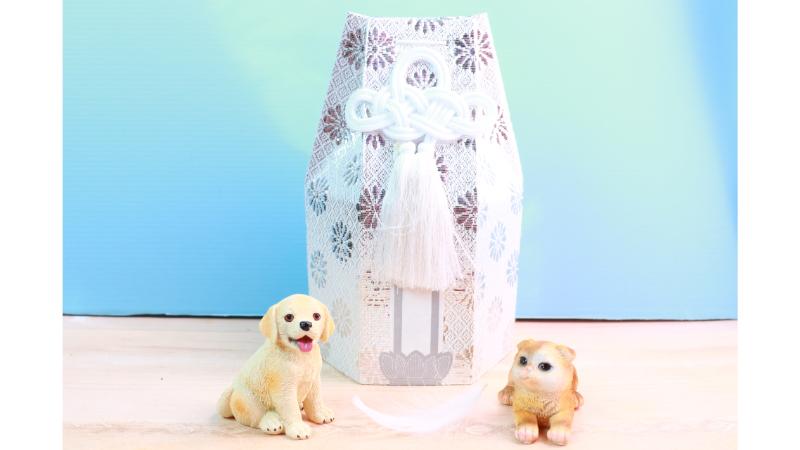 白いペット用の骨壺と犬と猫の置物