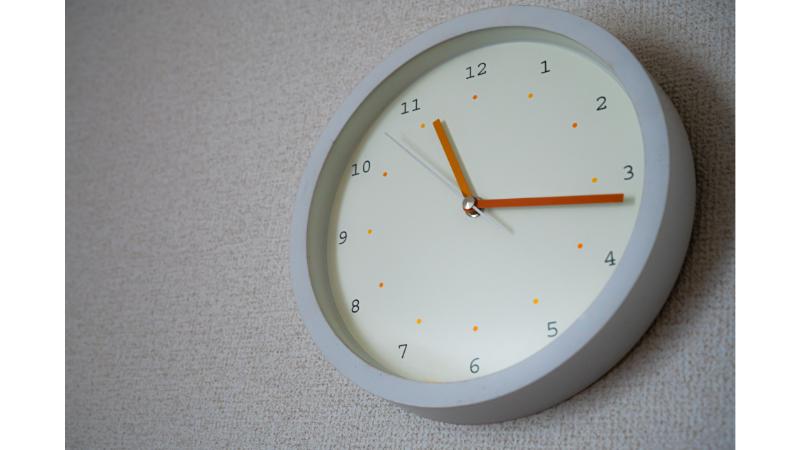 白い枠にオレンジの秒針の時計